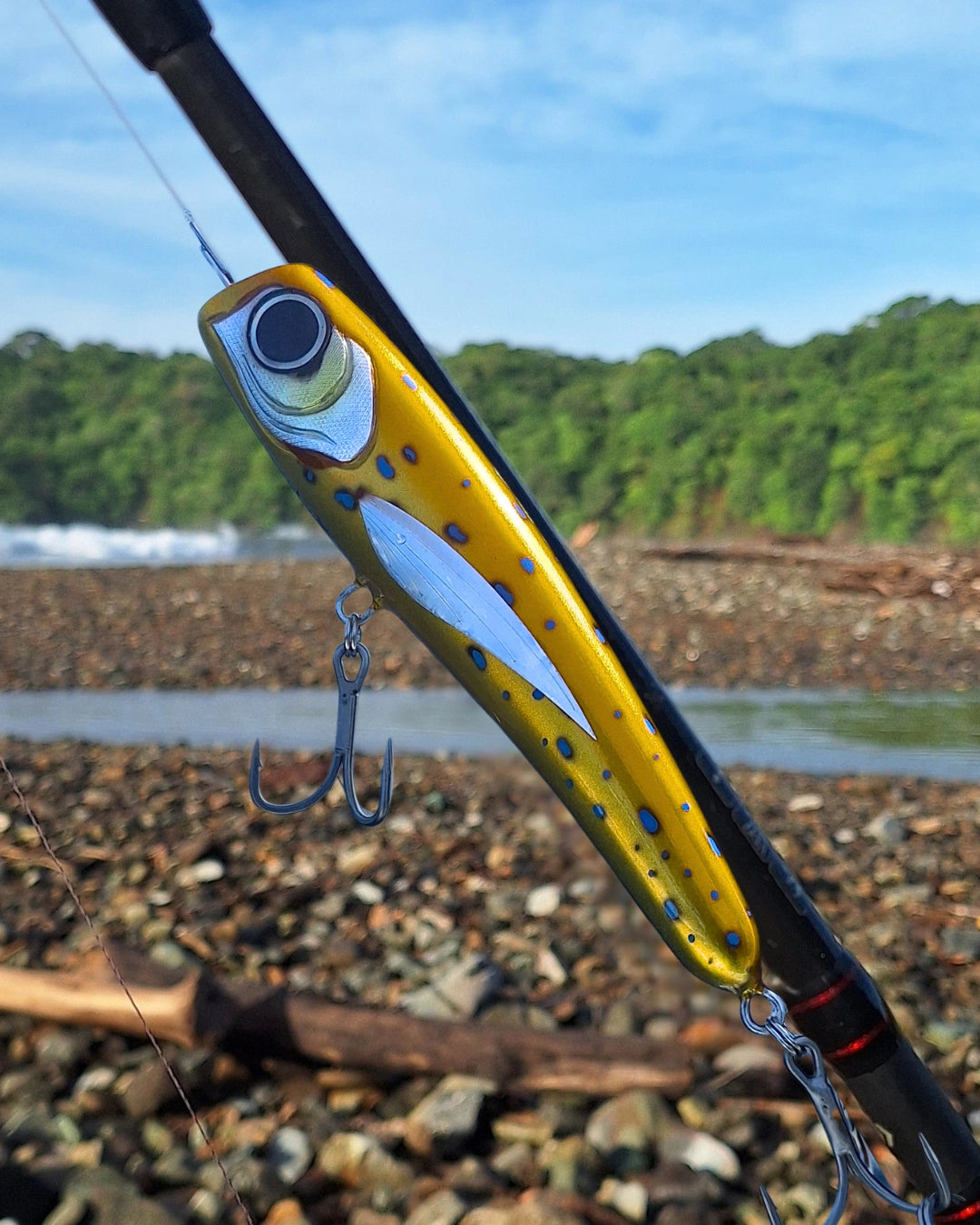 Gold diving popper fishing lure with blue spots.