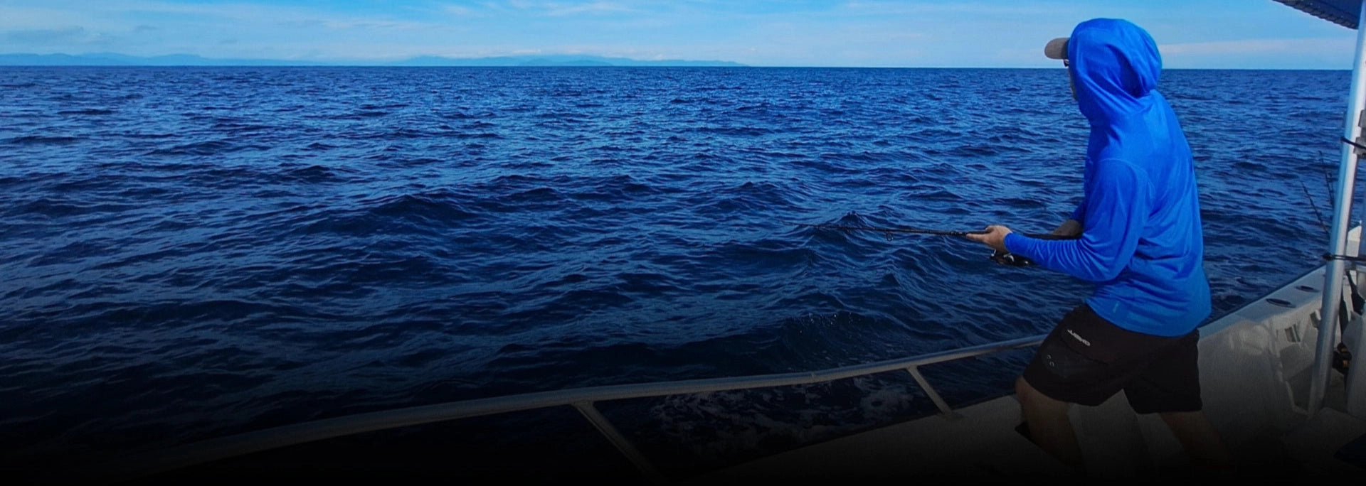 Angler fighting a big roosterfish from the boat off the coast of Panama.